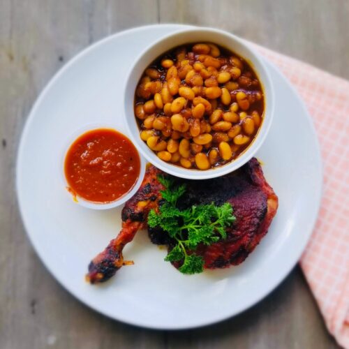 Smoked BBQ chicken leg quarters with baked bean